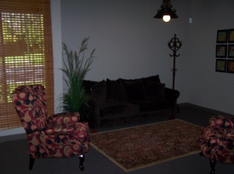 Inside of Southside Clubhouse showing a carpet, chair, plant, and couch.